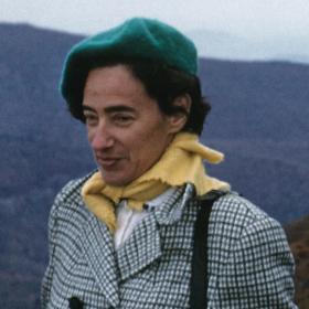 Olga Taussky-Todd dressed with a checked overcoat, yellow scarf and green beret. 